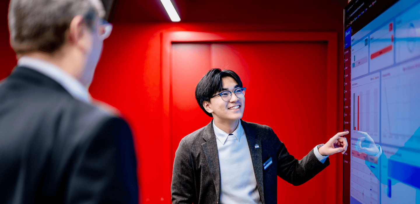 HIM Business School student discussing with lecturer while presenting