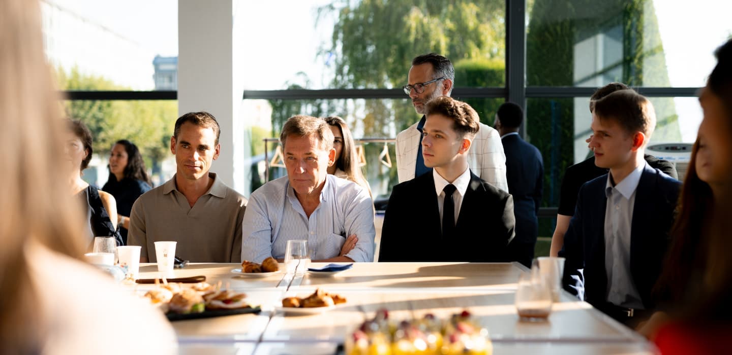 HIM Business School students at industry events, sitting besides business leaders